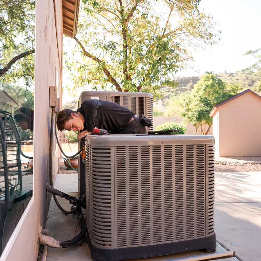 AC-technician-inspecting-AC-unit