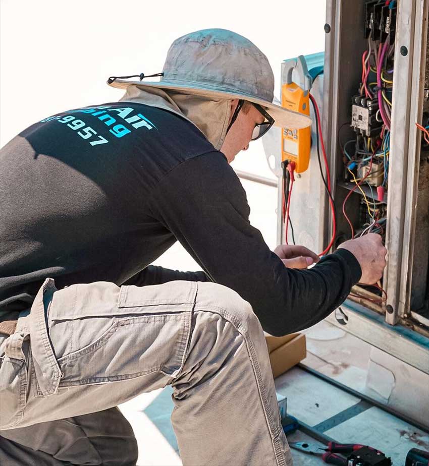 Lincoln air and plumbing technician works on air-conditioner-maintenance