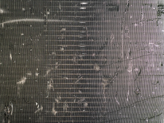 AC hail damage inspection Phoenix AZ – close-up of damaged air conditioner condenser fins.